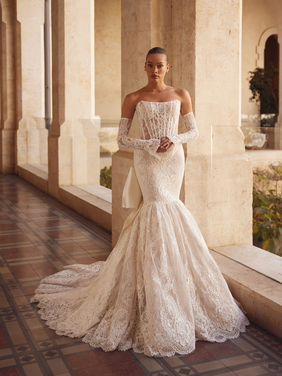 Love Couture Bridal Wedding Dresses. Woman in lace wedding dresses near old stone columns.