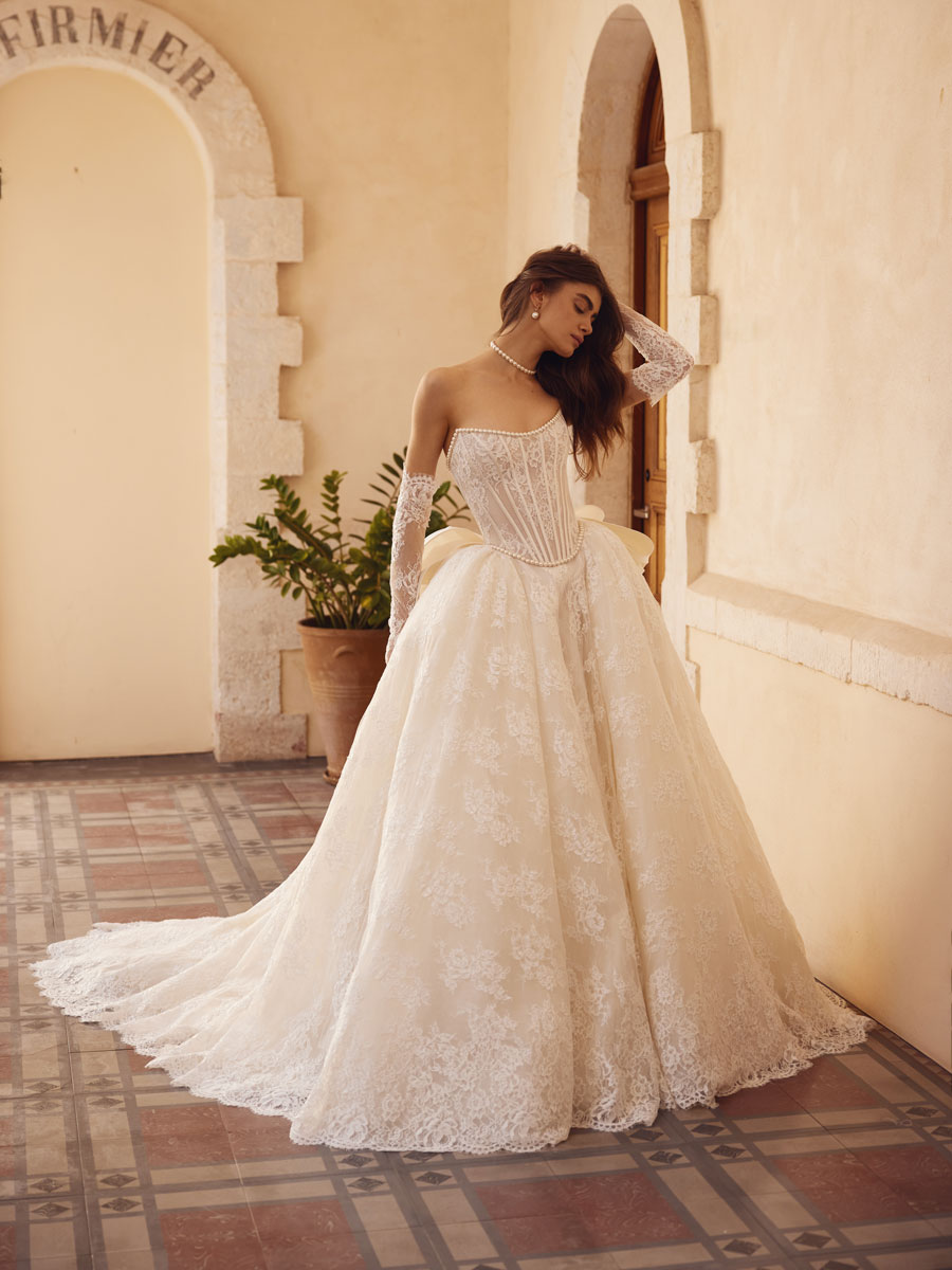 Love Couture Bridal Wedding Dresses. Bride in intricate lace wedding dresses near ancient columns.