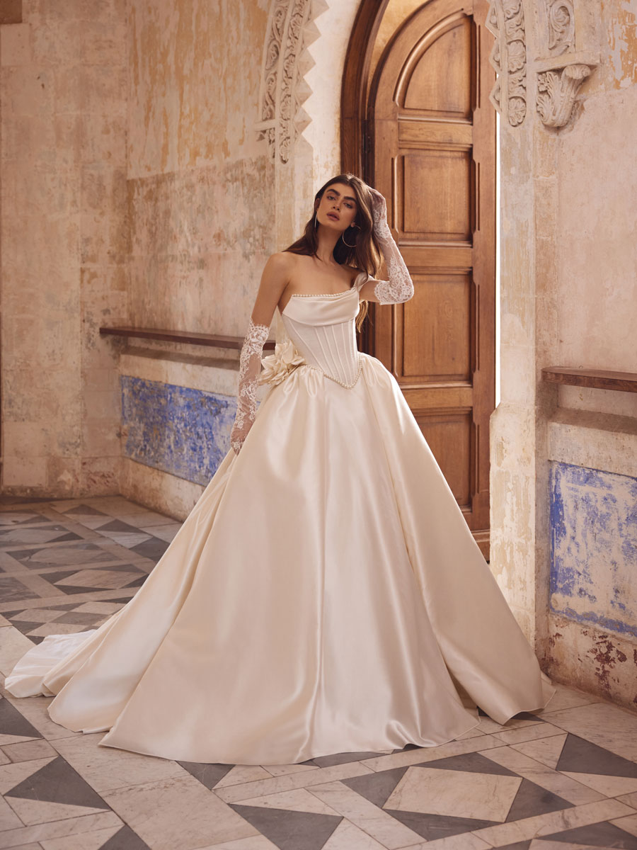 Love Couture Bridal Wedding Dresses. Floral lace wedding dresses worn by a woman at historic ruins.