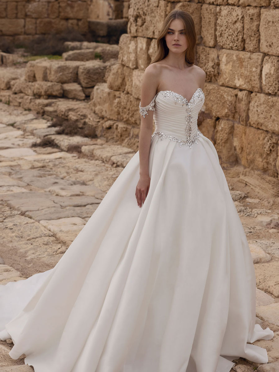 Love Couture Bridal Mother Wedding Dresses. Contemplative woman in wedding dresses by historical ruins.