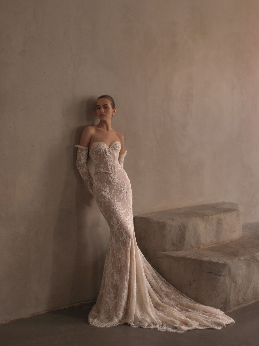 Woman in an intricate, floral lace Love Couture Bridal Wedding Dresses.