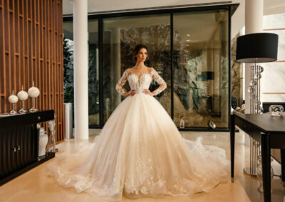 A beautiful bride in a wedding dresses gazes at her reflection in a mirror, radiating elegance and joy on her special day.